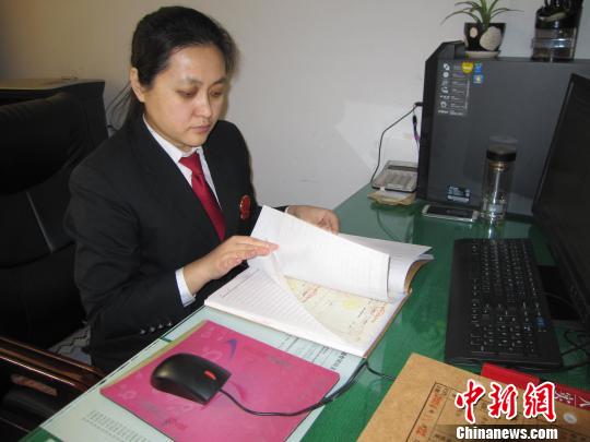 图为刘彦在翻阅案卷。　李忠勇 摄