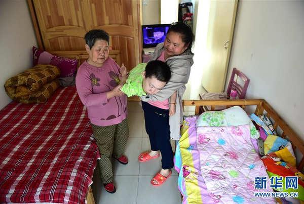 　5月19日，谢秀英和女儿高志萍一起帮梦云活动身体。