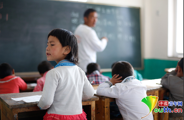 　6岁的藏族女孩黄娜姆措站着听黄老师讲课。黄三英的课堂上氛围很活跃，孩子们跟黄老师一起，又学习、又玩耍。中国青年网记者 张炎良 摄