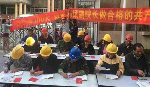 2016年5月23日，一群头戴安全帽，打扮为民工模样的人在江西高院门前，坐成三排抄写党章。