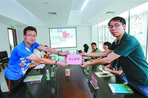 　　5月25日，益客暖流爱心众筹分享会在高明好人工作室开启。爱心商家代表(右)向公益联盟单位代表献上爱心款项。
