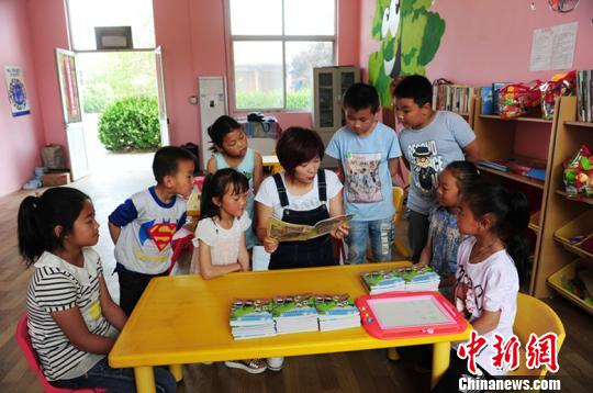 据了解，每个“留守儿童之家”专配一名儿童福利主任，负责教学设施管理和留守儿童的福利救助。图为儿童福利主任正在给孩子们传授知识。　温徐旺 摄