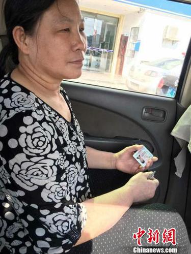 王女士坐上警车给儿子送身份证。　姚振男　摄