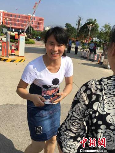 王女士将儿子身份证送到考点门口交给送考老师。　姚振男　摄