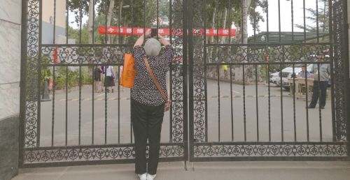 7日上午开考后，已经看不到孙子的李桂荣迟迟不愿离开，她想拍下考场内的照片，以作留念。本报记者魏新丽摄