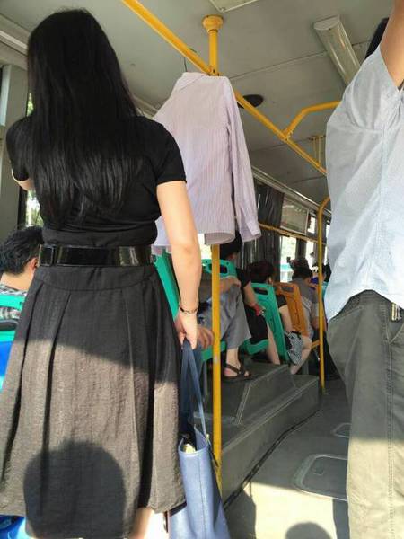 年轻女子在公交车厢内晾晒衣服