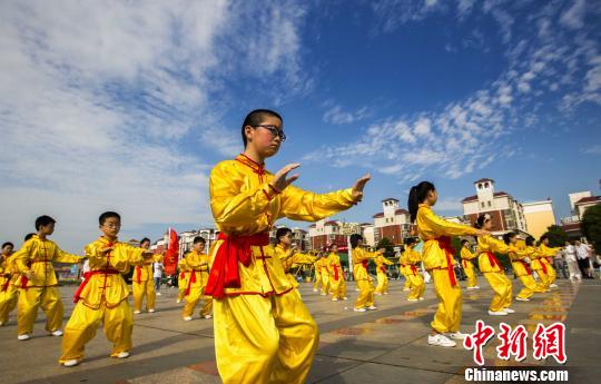 身着黄色统一古式服装的少年打太极拳。　傅建斌　摄