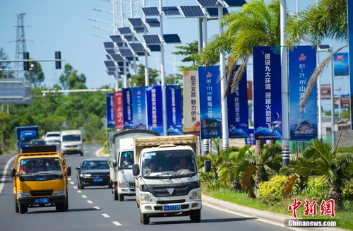 6月24日，海南省文昌市旅游大道的太阳能路灯杆上悬挂着火箭“首发”宣传广告。长征七号运载火箭发射日期临近，中国首个滨海航天发射中心——文昌航天发射场所在地海南省文昌市龙楼镇将迎来“首发”，中国的“卡纳维拉尔角”正揭开神秘面纱。中新社记者 骆云飞 摄