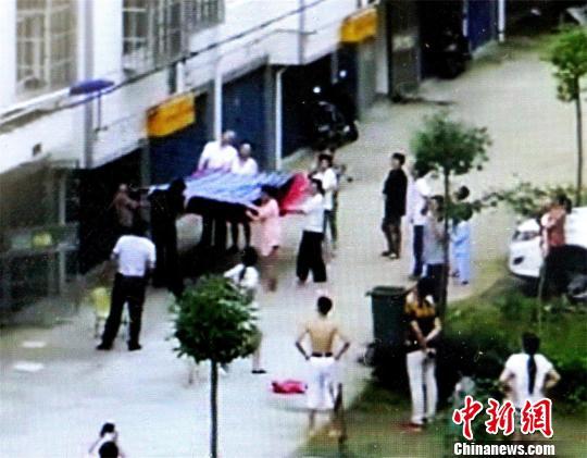小区居民将棉被、床单等物抱出，准备接住男孩 宋俊初 摄