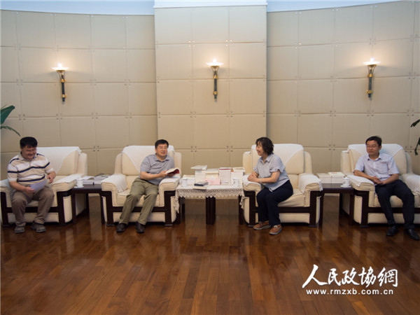 图为全国政协委员周秉建（右二）与人民政协报社党组书记、总编辑周北川（左二）进行座谈交流