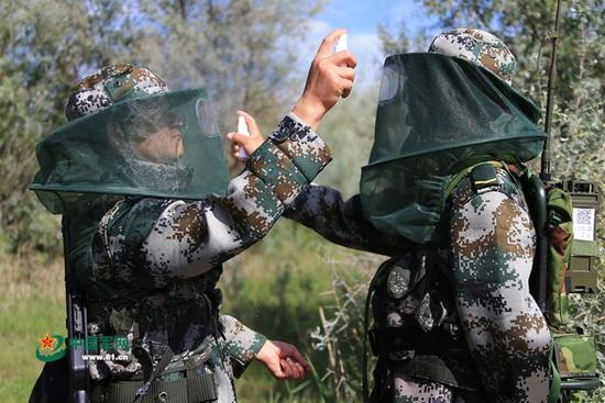 外出巡逻出发前，连队官兵互相为对方喷洒驱蚊液。