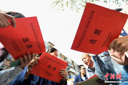 资料图：5月6日，山西太原老军营一社区的选民将选票放入投票箱中。当日，山西省基层人大代表换届选举全面展开。武俊杰 摄