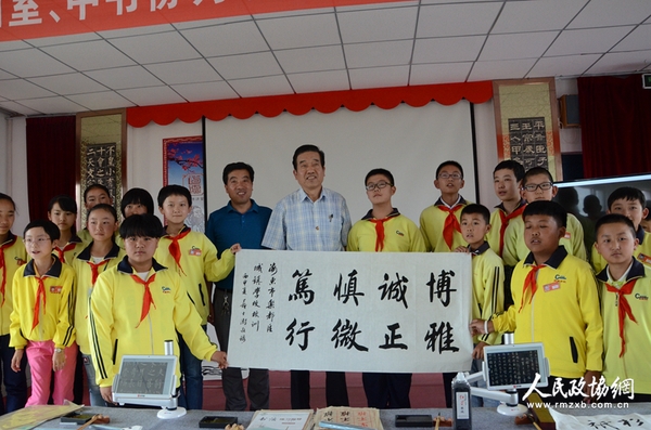 图片说明：政协委员与学生展示创作的书法作品。