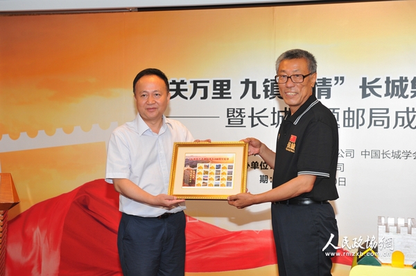 中国集邮总公司总经理邓慧国向中国长城学会副会长董耀会赠送《长城保护条例颁布10周年纪念》个性化邮票
