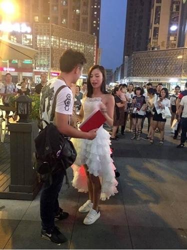 送哈雷送房子，只为博男神一个点头！此番情景瞬间吸引了大量路人围观。被求婚的男生，明显点惊慌，面对突然发生的一切，显得毫无准备且难以置信。