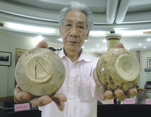 图为闻长庆展示刻有类希腊字母的古越青瓷器。（南华 摄） 