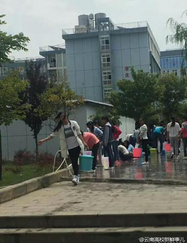 图为学生排队提水。