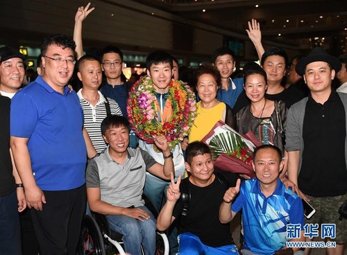 里约残奥会乒乓球冠军葛杨（中）在首都国际机场与人们合影留念。 新华社记者贺长山摄 图片来源：新华网