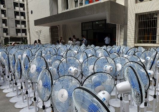 ↑9月22日，在发生甲醛超标的广东财经大学“30栋”学生宿舍楼前，大量落地电风扇等待被发放，用以帮助宿舍内通风。 新华社记者 梁旭 摄