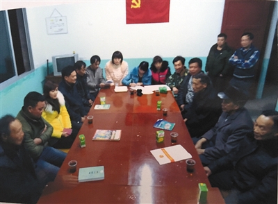 庄里村两委开会时的照片，图中穿迷彩服者是周炳耀。这是他为数不多的工作照之一。