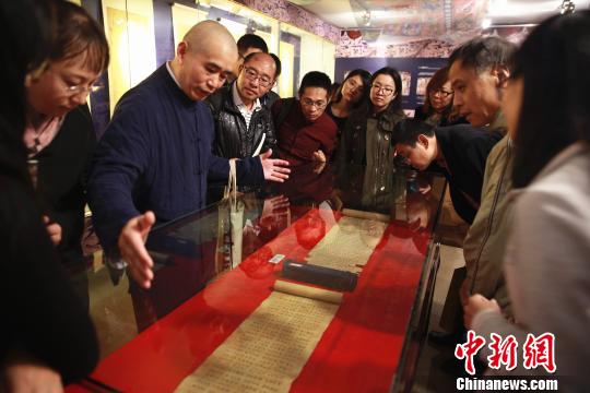 敦煌卷子珍品吸引众多观众，学者正在讲解其中奥妙。　戴琪　摄