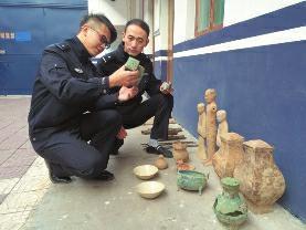 昨日，兴平市公安局刑侦大队东城中队，民警查看被追缴回来的文物 华商报记者 薛望 摄