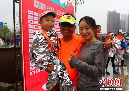 来自广州的李强夫妇用儿童车，载着4岁的儿子，一家三口完成了在桂林举行的半程马拉松比赛。　欧惠兰 摄