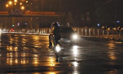 昨日，大望路，行人正在冒雨过人行道。 新京报记者 王飞 摄