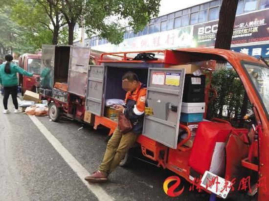 11月21日，芦淞市场，一位快递员在等待客户接收包裹(图文无关)(记者谢慧摄)