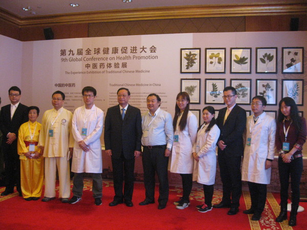 五、王国强与中医药体验展的工作人员留影。 人民政协网记者  张春莉  摄影