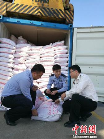 图为海关关员、缉私警察查看涉嫌走私大米 周磊 摄
