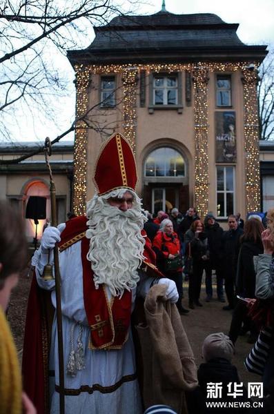 12月11日，在德国法兰克福古代雕塑博物馆开设的圣诞市场上，装扮成圣诞老人的工作人员向人们发放礼物。