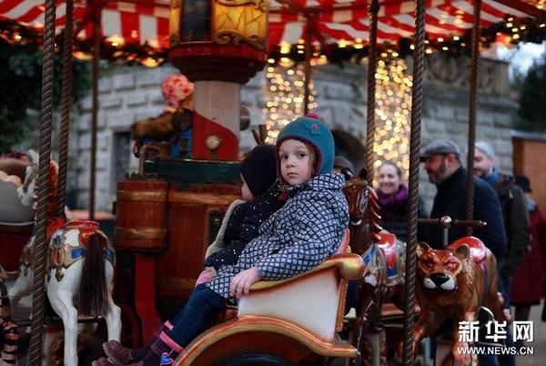 12月11日，在德国法兰克福古代雕塑博物馆开设的圣诞市场上，孩子们乘坐旋转木马。