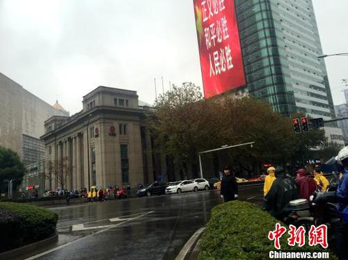 新街口是南京的市中心，现场所有交通信号灯都已变成红灯，往日熙攘热闹的新街口变得静止。车辆缓缓停住，司机自发按响喇叭，主动的鸣笛志哀1分钟；行色匆匆的路人也停下脚步在寒风中低头默哀。　盛捷 摄
