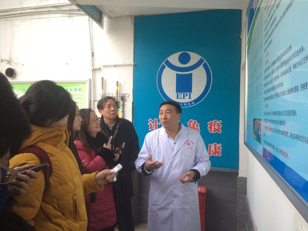 陕西省安康市茨沟镇中心医院院长晏显兴（右）在向记者介绍如何破解农村医疗难题。后排右二为陕西省卫生计生委副主任陈昭。人民政协网记者张春莉  摄