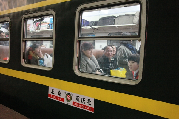 乘坐首趟加开旅客列车离京回家的人们。