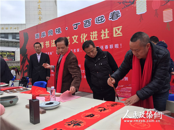 福建省连横书画院院长连明生（右）在书写春联。