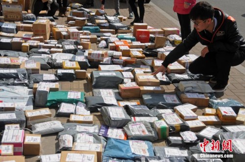 资料图：山西太原一高校外，学生们在地摊上找寻各自的快递。武俊杰 摄