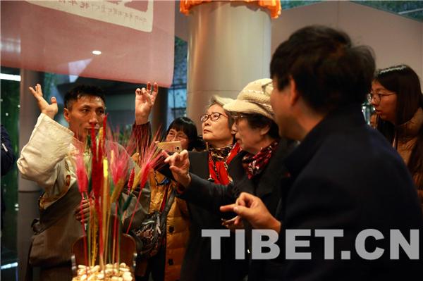 △图为现场观众体验藏式年俗，摄影：陈卫国