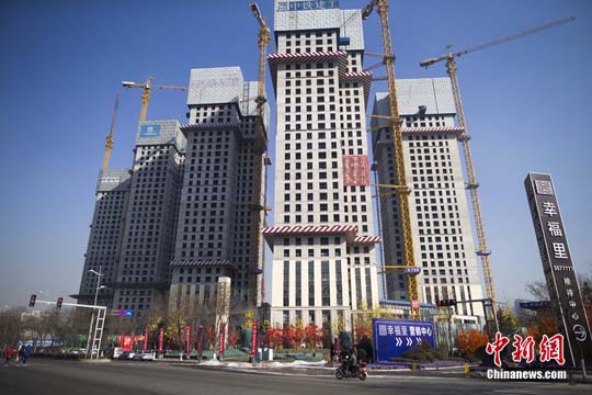 资料图 民众从一在建商业楼盘前经过。<a target='_blank' href='http://www.chinanews.com/'>中新社</a>记者 张云 摄