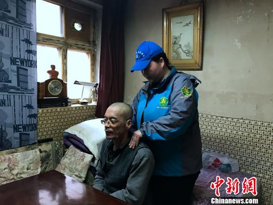 服务人员帮助残疾人做按摩。　孙睿　摄