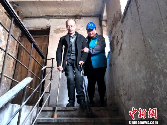 天气晴朗时，服务人员还会协助残疾人下楼，出去走走。　孙睿　摄