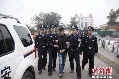 图为将网上追捕逃犯押回审讯。　黄卓 摄
