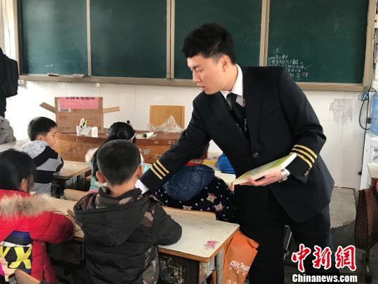 空乘人员给孩子们送书。　沈蕾 摄
