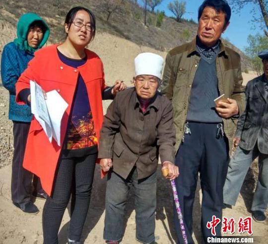 王万芳在贫困户入户调查时，走进演武乡佛岔村马忠玲家和残疾老人在一起。　侯志雄 摄