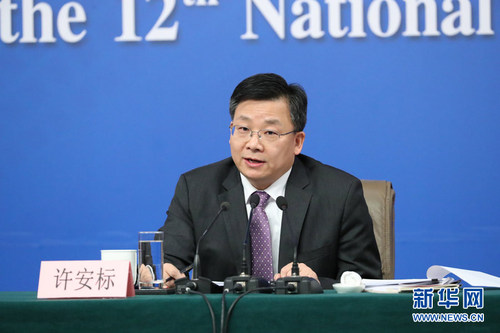 图为全国人大常委会法工委副主任许安标回答记者提问。