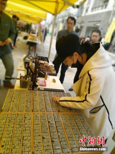 作为四大发明之一的活字印刷术，它的展示吸引了一些市民的驻足观看，随着时代的发展，艺术家通过文化方面的创新将他们衍生品应用到生活当中，例如项链、首饰等多种小饰品。 王秋兰 摄