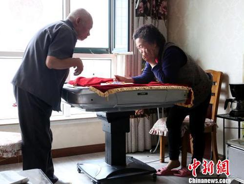 图为潘绍斌夫妇正在玩跳棋。　张海雯 摄