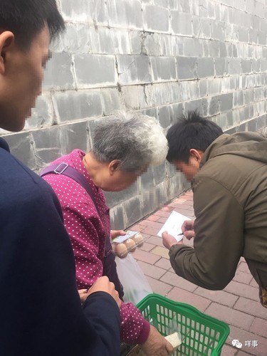有老人上前询问，经理上前登记派发团购券。