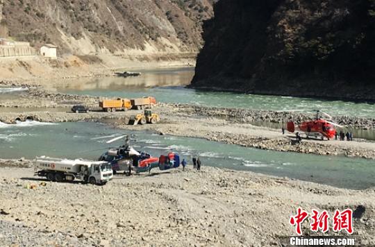 直升机在火场附近河滩上加油、挂桶。　钟欣 摄